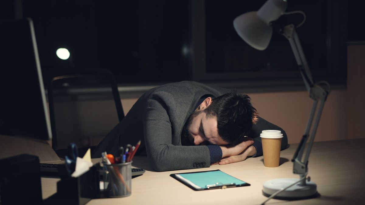 Exhausted employee asleep at desk after long hours