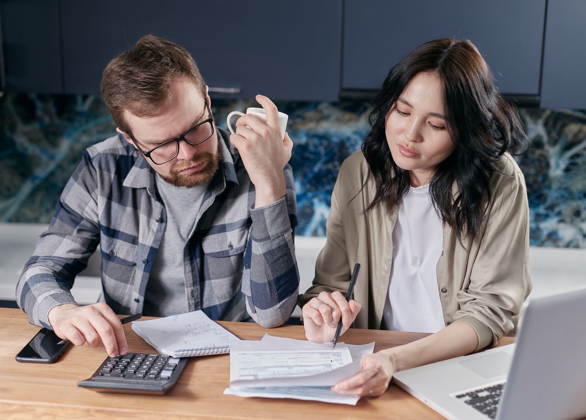 Couple reviewing household bills with a calculator