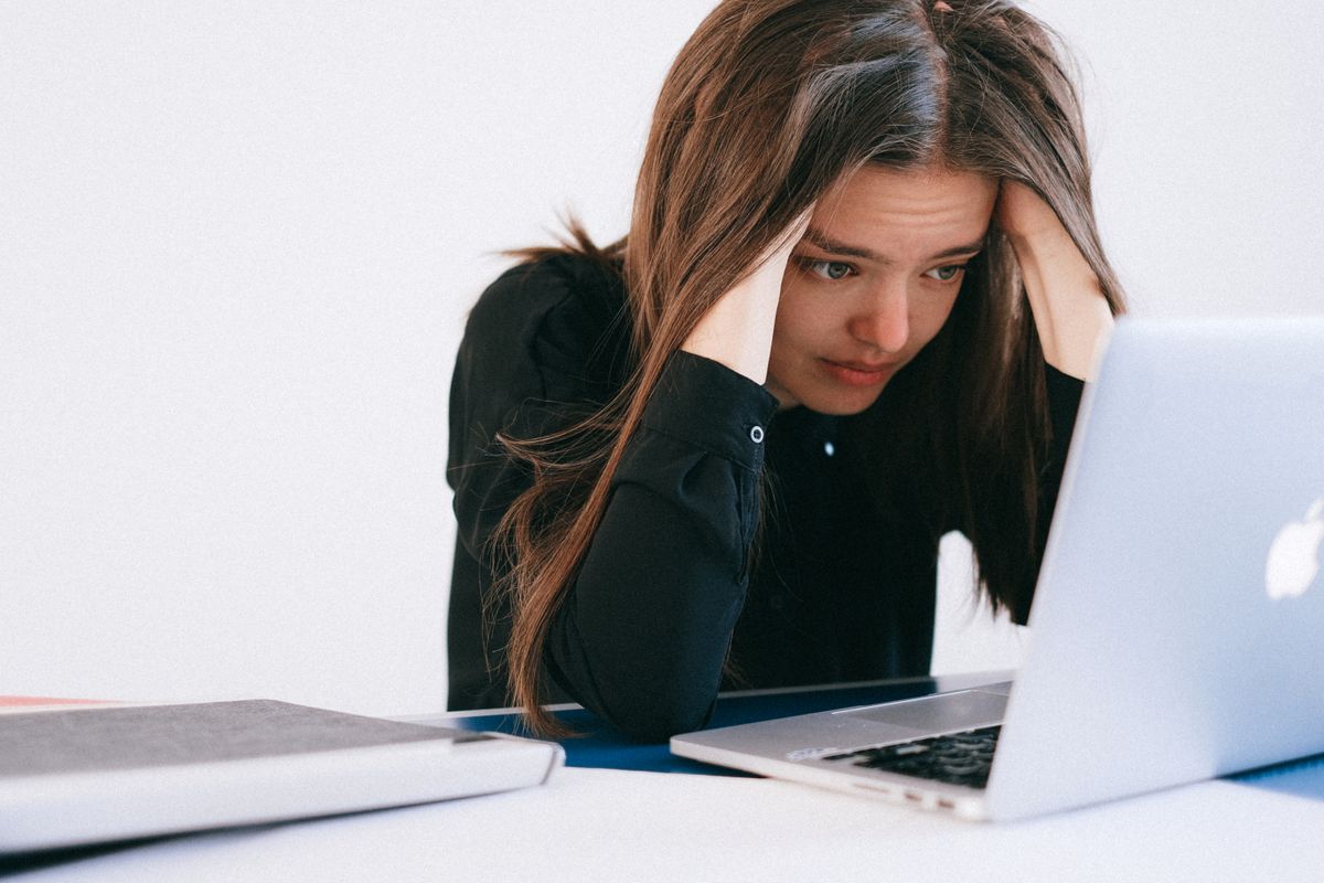 Woman stressed at laptop, burnout is not covered by ACC